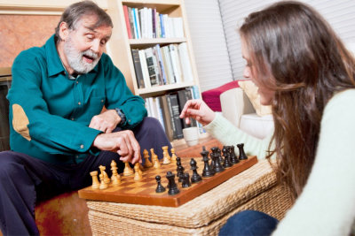 caregiver and a senior man playing chess