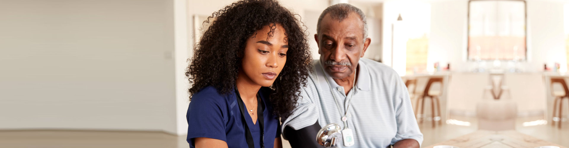 caregiver checking her patient blood pressure